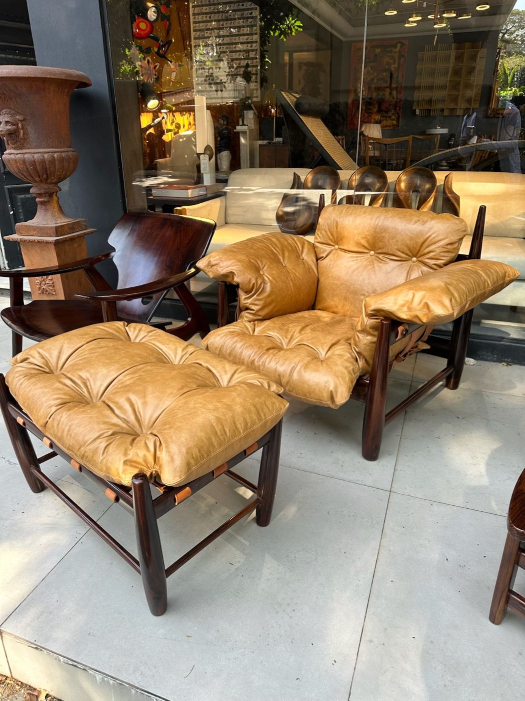 Poltrona de couro caramelo com estrutura em jacarandá e banqueta